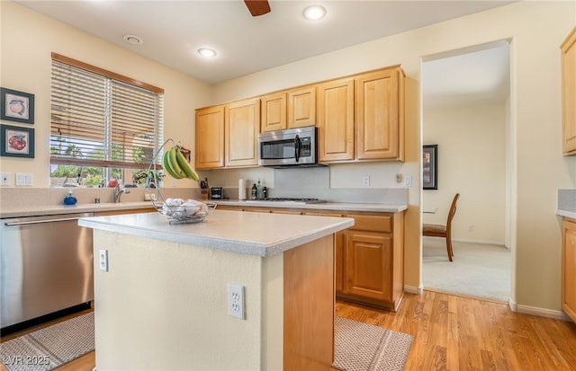 532 Kavanagh Pl, Las Vegas, NV 89123 - kitchen with appliances with stainless steel finishes, light brown cabinets, light countertops, light wood-type flooring, and a center island