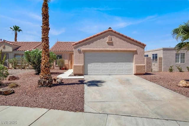 612 Moontide Ct, Henderson, NV 89011 - view of front of house with a tiled roof, stucco siding, concrete driveway, a garage, and a gate
