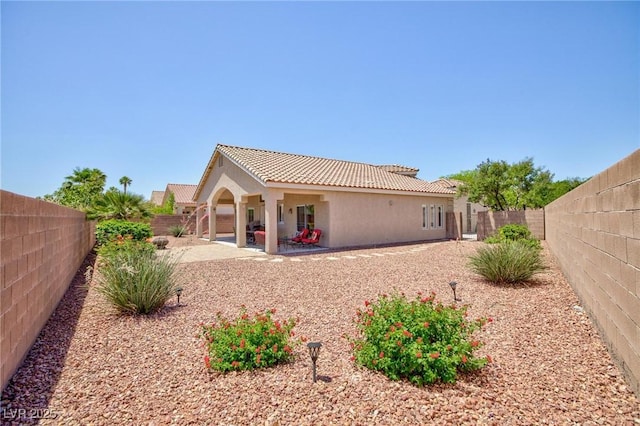7816 Glowing Peak St, Las Vegas, NV 89131 - rear view of house featuring a fenced backyard, a patio area, a tiled roof, and stucco siding