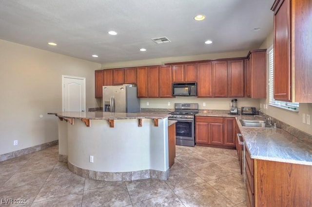 4016 Gaster Ave, North Las Vegas, NV 89081 - kitchen featuring stainless steel appliances, recessed lighting, a kitchen island, a breakfast bar, and light stone counters