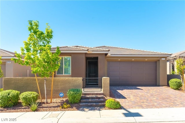 10711 Silver Pond Ave, Las Vegas, NV 89135 - view of front of home with decorative driveway, stucco siding, an attached garage, and a tiled roof