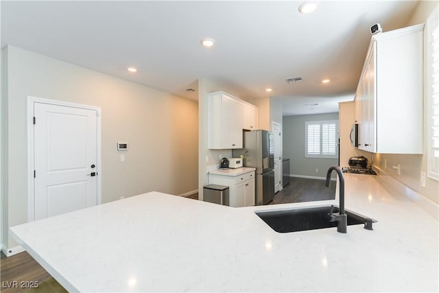 10711 Silver Pond Ave, Las Vegas, NV 89135 - kitchen featuring appliances with stainless steel finishes, white cabinetry, recessed lighting, light stone countertops, and dark wood-style floors