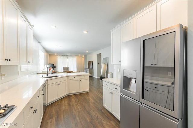 10711 Silver Pond Ave, Las Vegas, NV 89135 - kitchen featuring stainless steel appliances, dark wood-type flooring, a peninsula, white cabinets, and light countertops