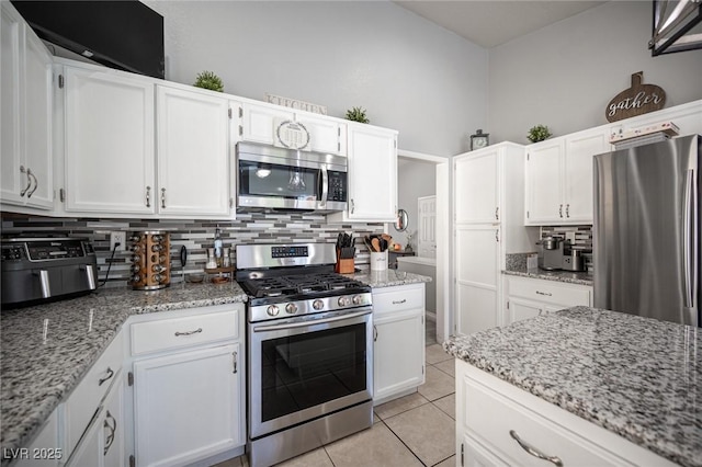 1553 Bright View Dr, Las Vegas, NV 89119 - kitchen with stainless steel appliances, tasteful backsplash, and white cabinets