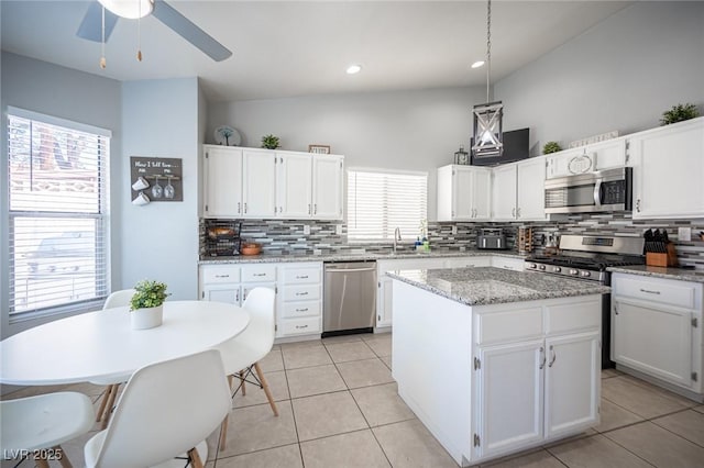 1553 Bright View Dr, Las Vegas, NV 89119 - kitchen featuring appliances with stainless steel finishes, decorative backsplash, a kitchen island, white cabinets, and recessed lighting
