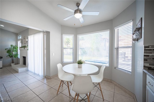 1553 Bright View Dr, Las Vegas, NV 89119 - dining room featuring a ceiling fan, lofted ceiling, a fireplace, and light tile patterned floors