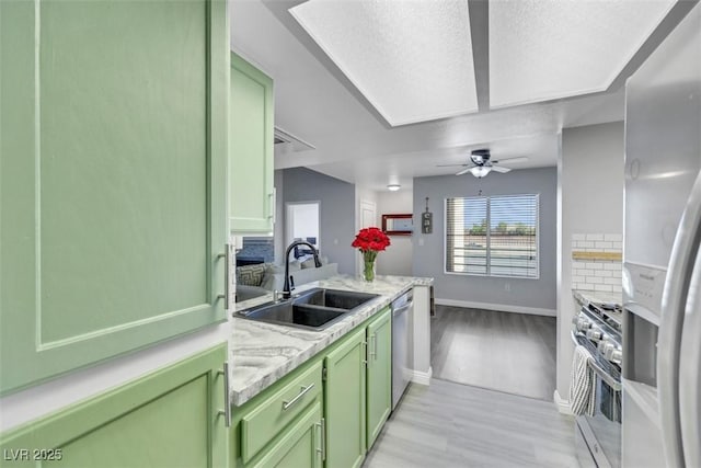 7100 Pirates Cove Rd Unit 2076, Las Vegas, NV 89145 - kitchen with green cabinets, appliances with stainless steel finishes, light wood finished floors, ceiling fan, and a peninsula