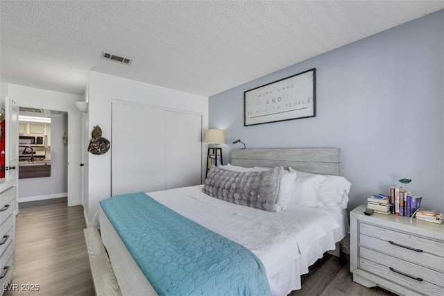 7100 Pirates Cove Rd Unit 2076, Las Vegas, NV 89145 - bedroom featuring wood finished floors, a closet, and a textured ceiling