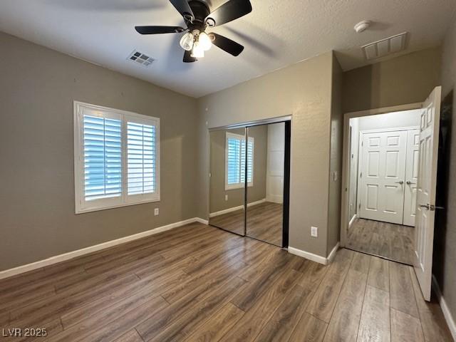 2704 Willow Wren Dr, North Las Vegas, NV 89084 - unfurnished bedroom featuring wood finished floors, a closet, and a ceiling fan