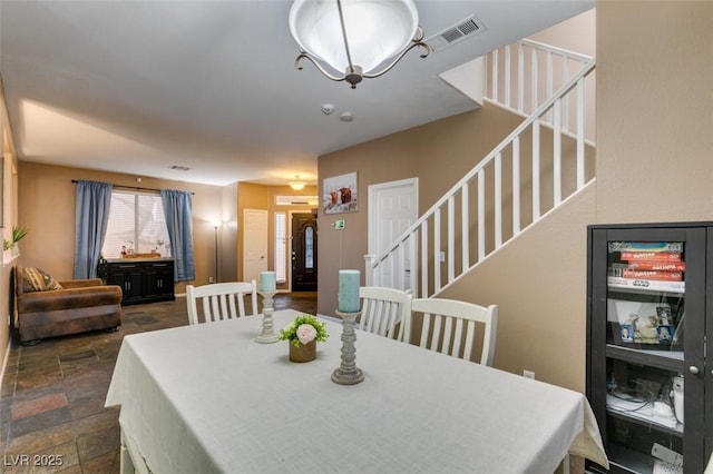4512 Long Horse Ct, Las Vegas, NV 89147 - dining space with stairs, dark stone finish floors, and a chandelier