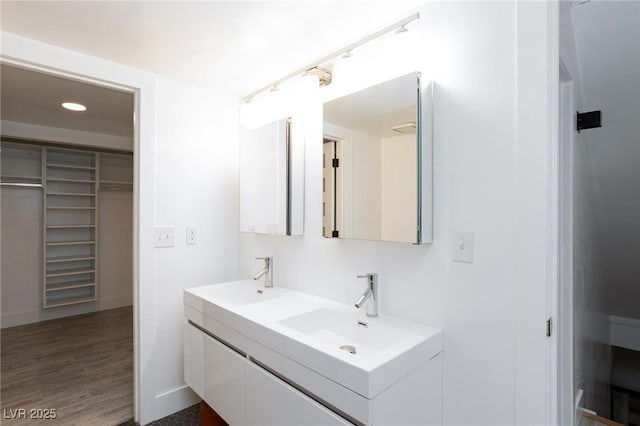 4778 Knotty Pine Way, Las Vegas, NV 89124 - bathroom featuring double vanity, a walk in closet, recessed lighting, and wood finished floors