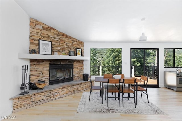 4778 Knotty Pine Way, Las Vegas, NV 89124 - dining room with healthy amount of natural light, wood finished floors, a stone fireplace, and lofted ceiling