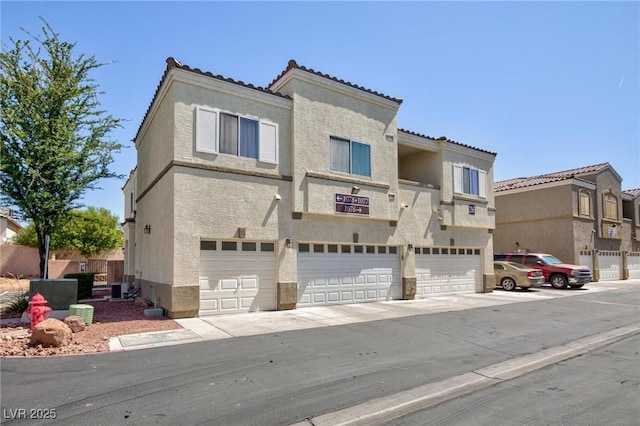 6170 E Sahara Ave Unit 1076, Las Vegas, NV 89142 - view of front of home featuring stucco siding, a garage, and a tiled roof