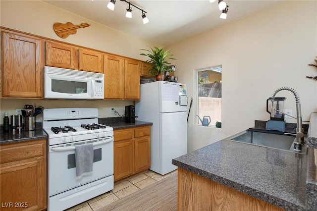 6170 E Sahara Ave Unit 1076, Las Vegas, NV 89142 - kitchen with white appliances, dark countertops, light tile patterned floors, and rail lighting