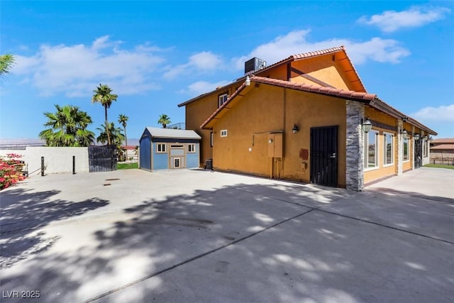 1385 Morning Sun Way, Las Vegas, NV 89110 - view of home's exterior with stucco siding, an outdoor structure, concrete driveway, and stone siding