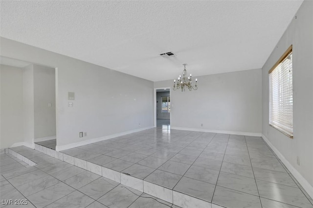 1385 Morning Sun Way, Las Vegas, NV 89110 - spare room with light marble finish floors, a chandelier, and a textured ceiling