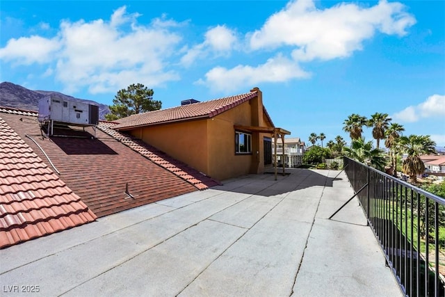 1385 Morning Sun Way, Las Vegas, NV 89110 - view of property exterior featuring a tiled roof, stucco siding, a chimney, and a balcony