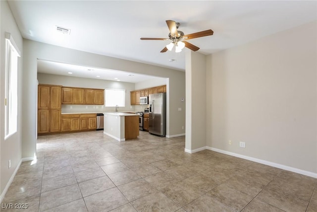 6591 Gertrude Ct, Las Vegas, NV 89141 - kitchen featuring stainless steel appliances, a ceiling fan, a center island, open floor plan, and light countertops
