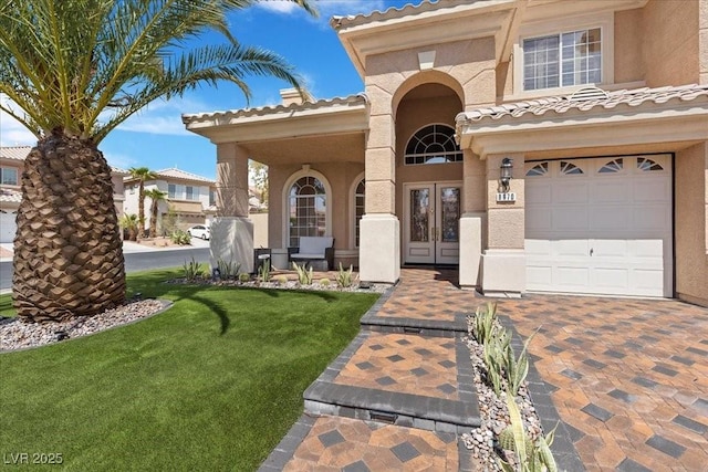 8970 Lansberry Ct, Las Vegas, NV 89147 - view of front of home featuring french doors, stucco siding, an attached garage, a front lawn, and a tiled roof