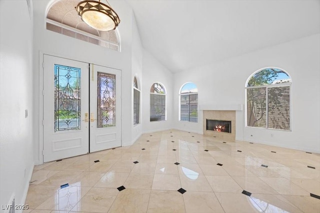 8970 Lansberry Ct, Las Vegas, NV 89147 - foyer entrance with high vaulted ceiling, tile patterned flooring, a glass covered fireplace, and french doors