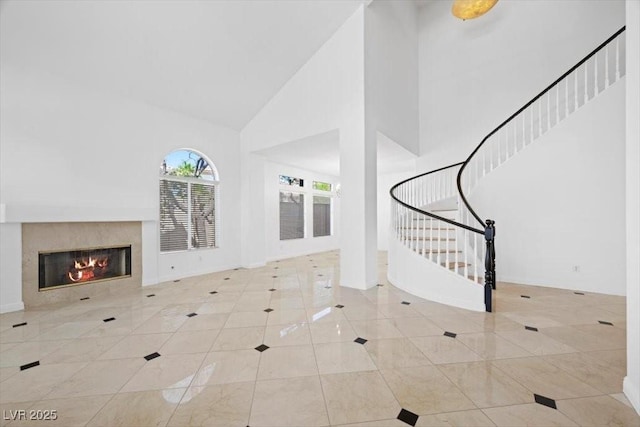 8970 Lansberry Ct, Las Vegas, NV 89147 - foyer entrance featuring high vaulted ceiling, a tiled fireplace, stairs, and tile patterned floors