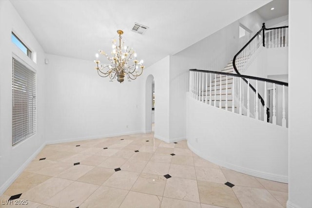 8970 Lansberry Ct, Las Vegas, NV 89147 - unfurnished room with arched walkways, stairway, a chandelier, and tile patterned floors