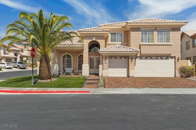 8970 Lansberry Ct, Las Vegas, NV 89147 - view of front facade with stucco siding, decorative driveway, a tiled roof, french doors, and an attached garage