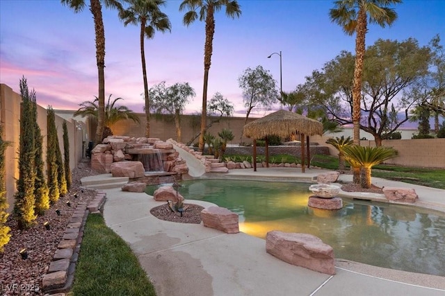 8970 Lansberry Ct, Las Vegas, NV 89147 - pool at dusk featuring a water slide and a fenced backyard