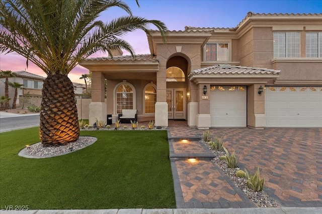 8970 Lansberry Ct, Las Vegas, NV 89147 - mediterranean / spanish-style house featuring stucco siding, a tiled roof, a lawn, decorative driveway, and a garage