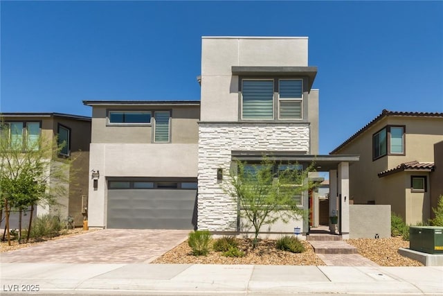 6927 Desert Finch St, North Las Vegas, NV 89084 - contemporary home with stucco siding, stone siding, decorative driveway, and a garage