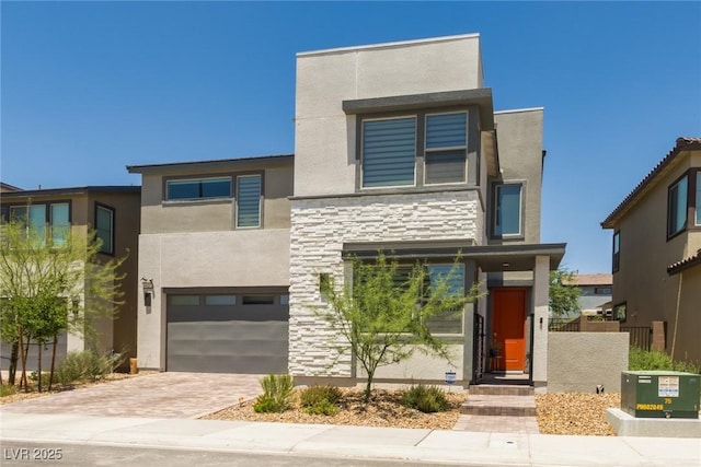 6927 Desert Finch St, North Las Vegas, NV 89084 - contemporary home with an attached garage, stone siding, stucco siding, and decorative driveway