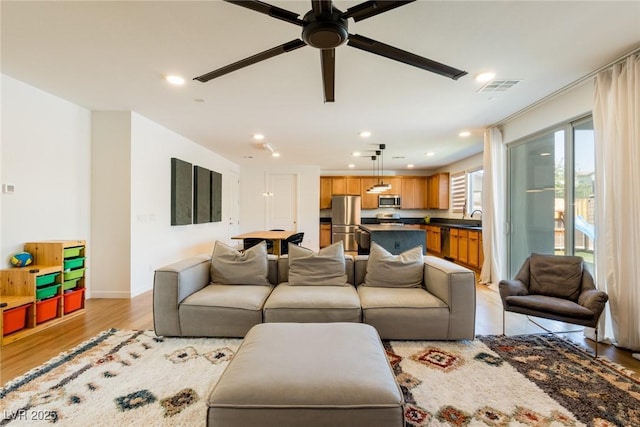 6927 Desert Finch St, North Las Vegas, NV 89084 - living area with light wood-type flooring, ceiling fan, and recessed lighting