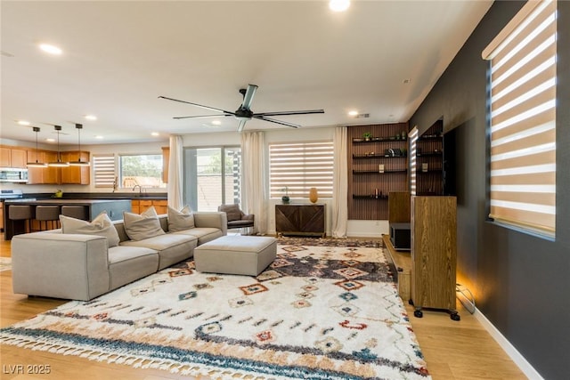 6927 Desert Finch St, North Las Vegas, NV 89084 - living room with light wood finished floors, a ceiling fan, and recessed lighting