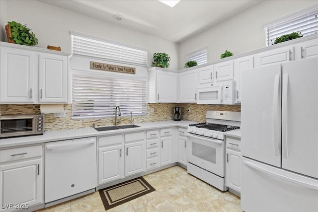 10413 Marymont Pl, Las Vegas, NV 89134 - kitchen with white appliances, light countertops, white cabinets, and decorative backsplash