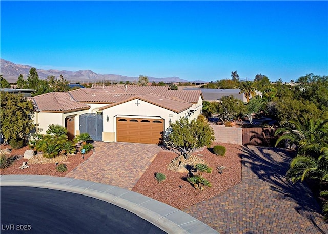 8604 Amber Autumn St, Las Vegas, NV 89131 - mediterranean / spanish-style house with stucco siding, an attached garage, a mountain view, and driveway