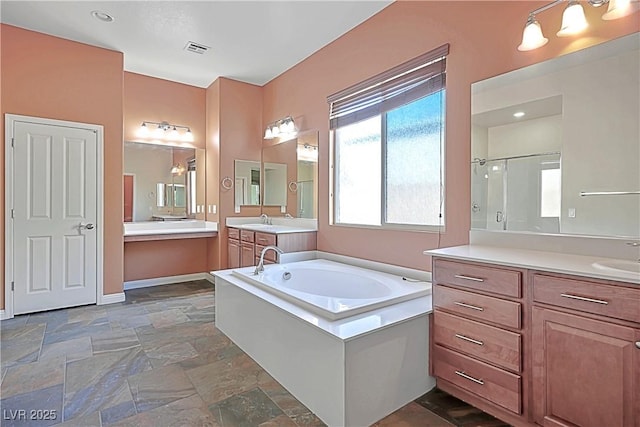 8604 Amber Autumn St, Las Vegas, NV 89131 - bathroom with stone tile floors, a bath, two vanities, and a stall shower
