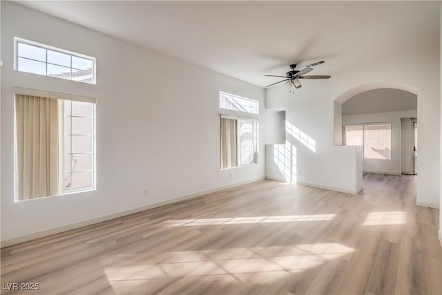 7021 Feather Pine St, Las Vegas, NV 89131 - unfurnished living room with ceiling fan, plenty of natural light, arched walkways, and wood finished floors