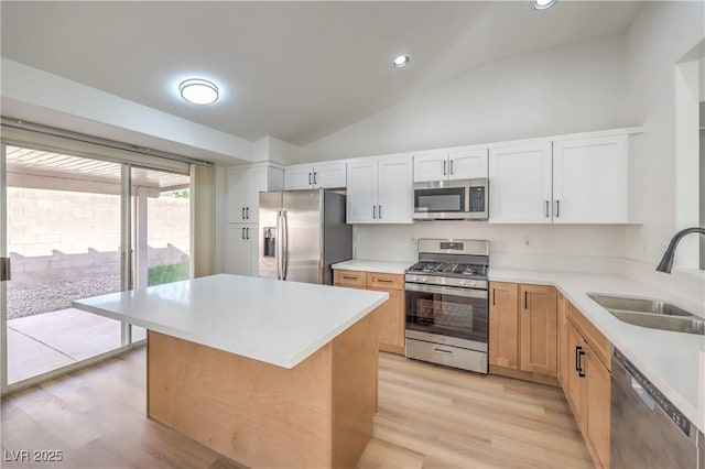 7021 Feather Pine St, Las Vegas, NV 89131 - kitchen with stainless steel appliances, vaulted ceiling, light countertops, light wood-style floors, and white cabinetry