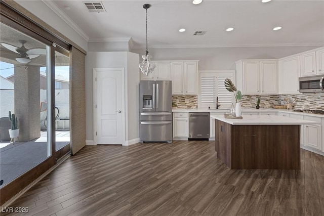 12 Golden View St, Henderson, NV 89012 - kitchen featuring appliances with stainless steel finishes, dark wood finished floors, ornamental molding, decorative backsplash, and white cabinetry