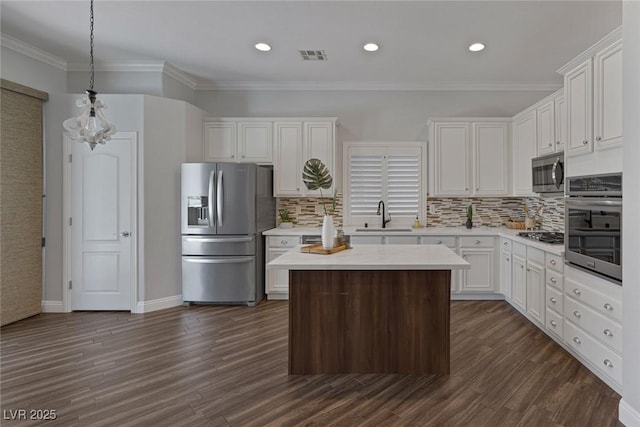12 Golden View St, Henderson, NV 89012 - kitchen featuring appliances with stainless steel finishes, light countertops, white cabinets, dark wood-style flooring, and a kitchen island