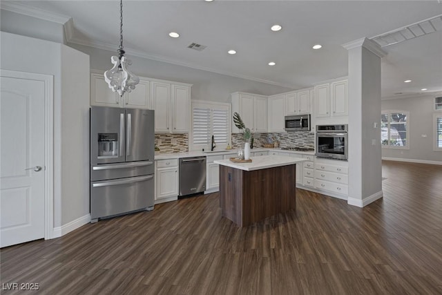 12 Golden View St, Henderson, NV 89012 - kitchen with appliances with stainless steel finishes, dark wood-type flooring, backsplash, light countertops, and crown molding