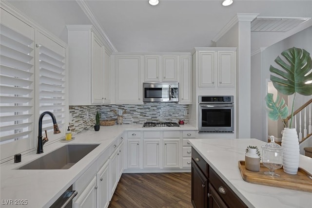 12 Golden View St, Henderson, NV 89012 - kitchen featuring stainless steel appliances, white cabinetry, backsplash, dark wood-type flooring, and light stone counters