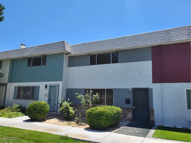 745 Greenbriar Townhouse Way, Las Vegas, NV 89121 - view of front of property with stucco siding and roof with shingles