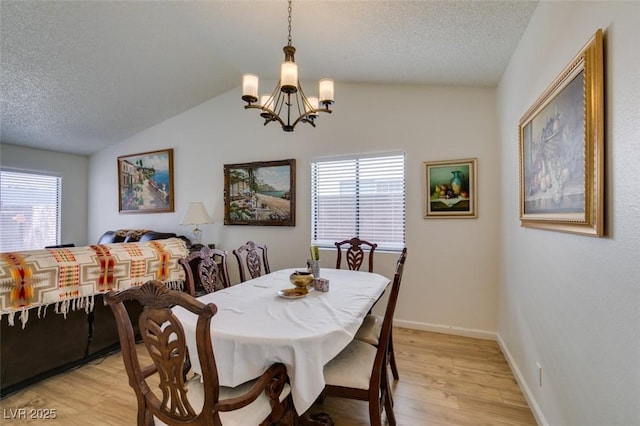 368 Umbria Way, Henderson, NV 89014 - dining area featuring a chandelier, light wood-style flooring, a textured ceiling, healthy amount of natural light, and vaulted ceiling