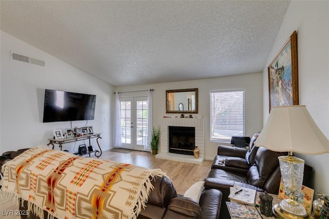 368 Umbria Way, Henderson, NV 89014 - living area with a textured ceiling, wood finished floors, healthy amount of natural light, lofted ceiling, and a fireplace