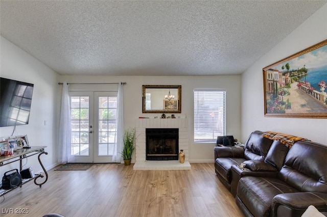 368 Umbria Way, Henderson, NV 89014 - living room with a textured ceiling, wood finished floors, a fireplace, and french doors
