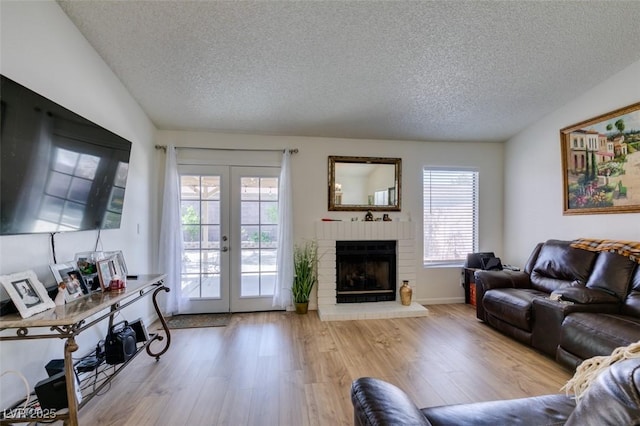 368 Umbria Way, Henderson, NV 89014 - living area featuring a textured ceiling, french doors, wood finished floors, and a brick fireplace