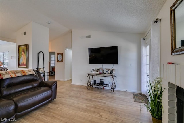 368 Umbria Way, Henderson, NV 89014 - living area with light wood-style floors, vaulted ceiling, a fireplace, and a textured ceiling