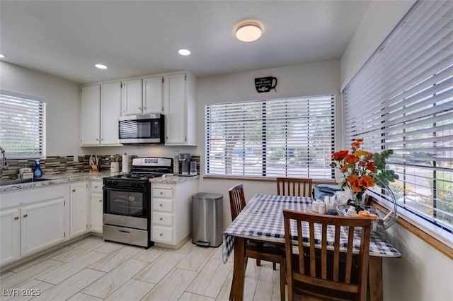 368 Umbria Way, Henderson, NV 89014 - kitchen with stainless steel appliances, plenty of natural light, white cabinets, recessed lighting, and light stone countertops