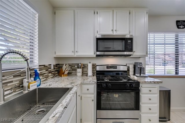 368 Umbria Way, Henderson, NV 89014 - kitchen with stainless steel microwave, range with gas stovetop, white cabinets, and tasteful backsplash